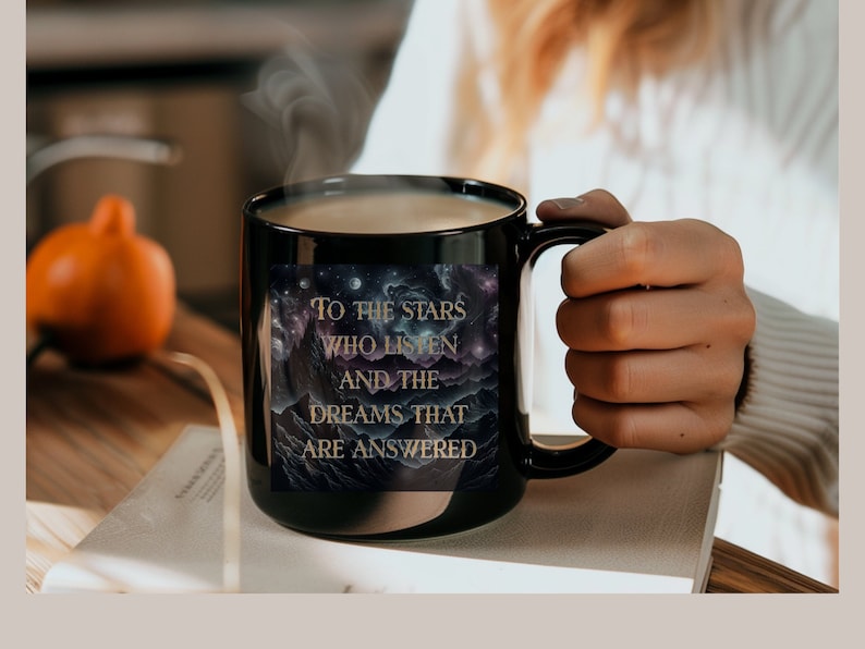Puede incluir: Taza de caf&eacute; negra con un dise&ntilde;o de galaxia y letras doradas que dicen "To the stars who listen and the dreams that are answered".