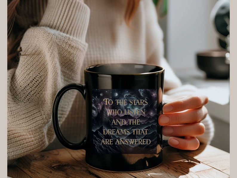 Puede incluir: Taza de caf&eacute; negra con borde dorado y dise&ntilde;o de galaxia. La taza tiene el texto "To the stars who listen and the dreams that are answered".