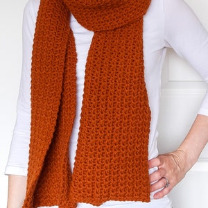 orange/brown crochet scarf on model