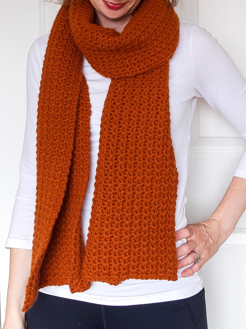 orange/brown crochet scarf on model