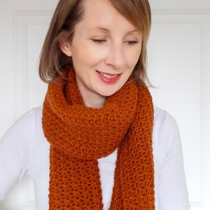 orange/brown crochet scarf on model