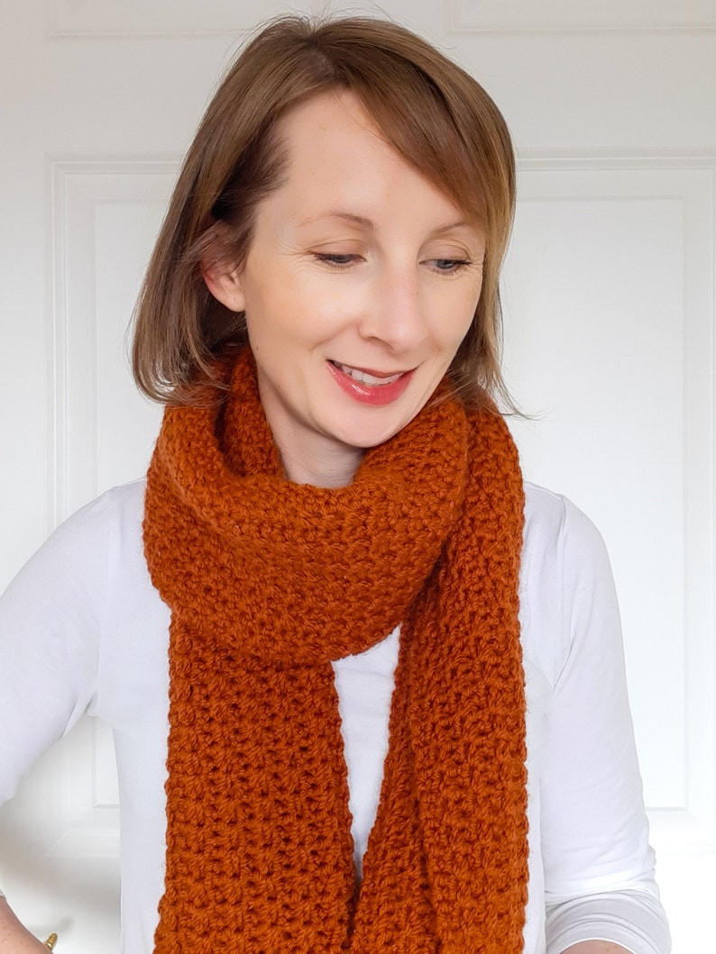 orange/brown crochet scarf on model