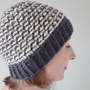 Puede incluir: Un gorro de punto gris y blanco con un patr&oacute;n de chevron. El gorro lo lleva una persona con el pelo corto y casta&ntilde;o.