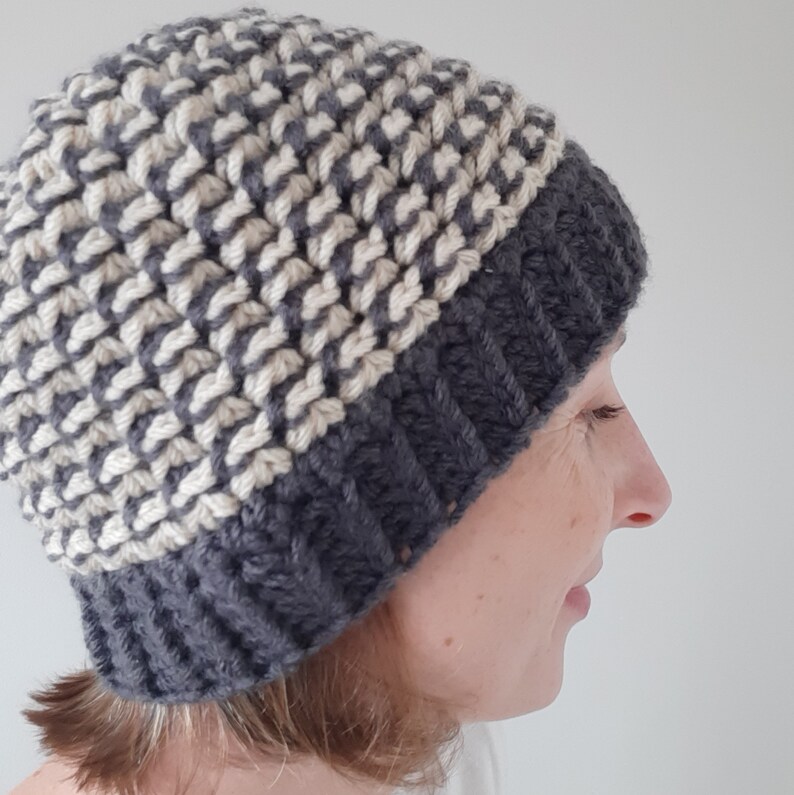 Puede incluir: Un gorro de punto gris y blanco con un patr&oacute;n de chevron. El gorro lo lleva una persona con el pelo corto y casta&ntilde;o.