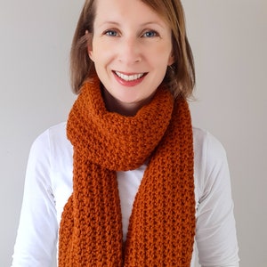 orange/brown crochet scarf on model