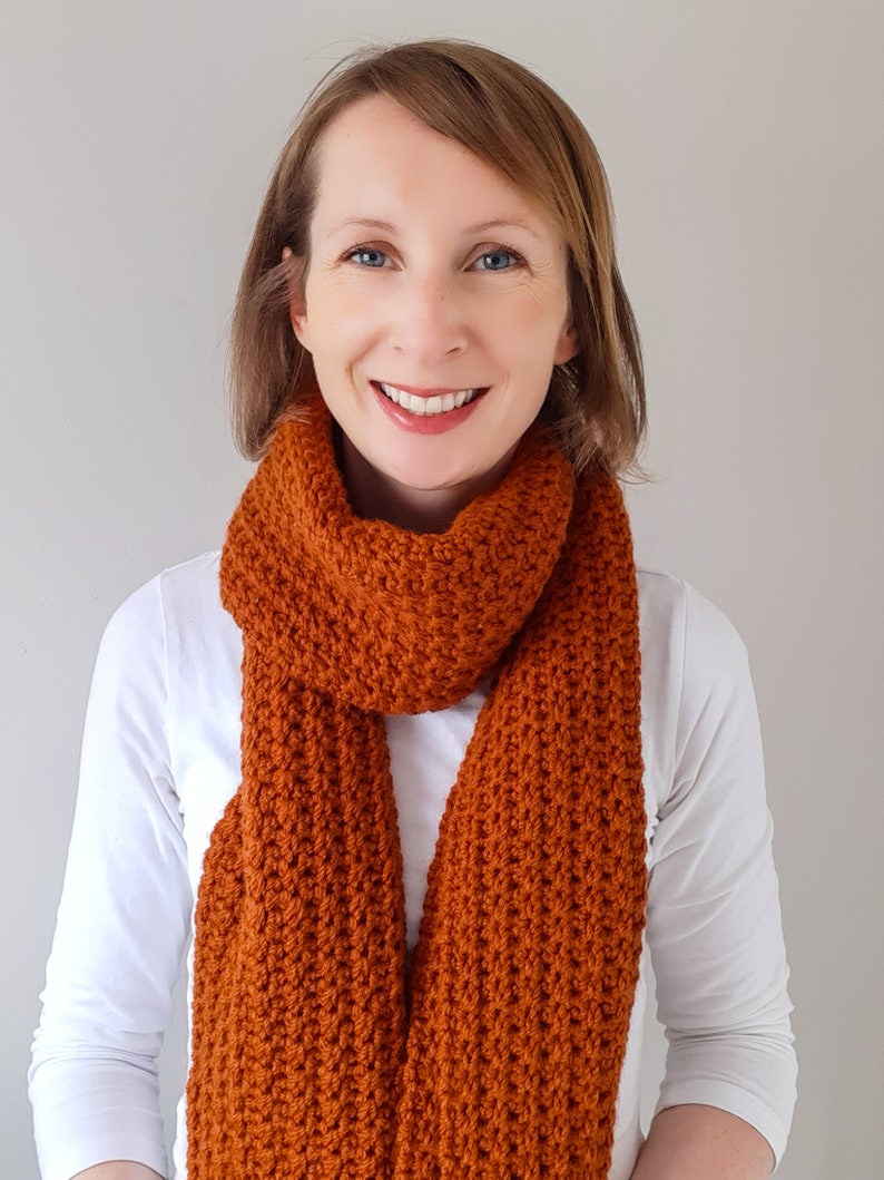 orange/brown crochet scarf on model