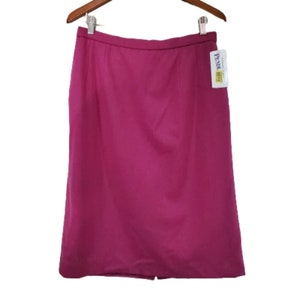 May include: A magenta knee-length skirt with a straight cut and a zipper closure. The skirt has a brand tag attached to the side.