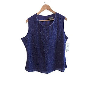 May include: A sleeveless royal blue blouse featuring an all-over pattern of dark blue sequins and beads. The top has a round neckline, a back button closure, and a brand label reading NOTATIONS that is visible at the inner collar area.