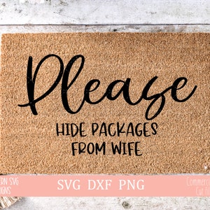 May include: A brown doormat with the text "Please Hide Packages From Wife" in black lettering. The doormat is made of coir and has a rough texture.