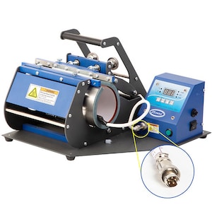 May include: A blue and black mug press machine with a digital display and handle. The machine has a cylindrical heating element and a control panel with buttons and a digital display. A white cable connects to the machine.
