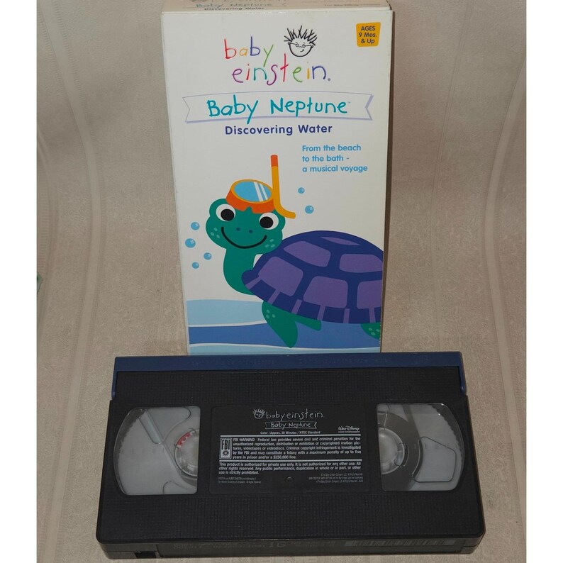 May include: A Baby Einstein "Baby Neptune: Discovering Water" VHS tape and box. The box features a cartoon turtle wearing a snorkel and the text "From the beach to the bath - a musical voyage."