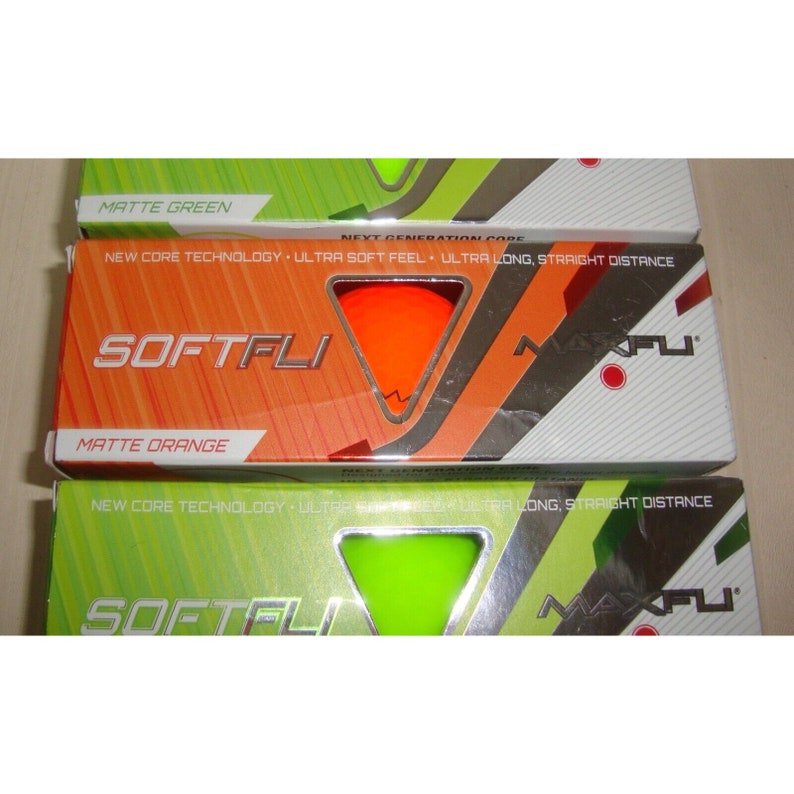 May include: Three boxes of golf balls, one with a green background and the text "Matte Green", one with an orange background and the text "Matte Orange", and one with a green background and the text "Matte Green". Each box features a golf ball in the center and the text "SOFTFLI" and "MAXFLI".