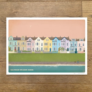 May include: A colourful illustration of a row of houses on a seaside esplanade. The houses are painted in shades of blue, green, yellow, pink, and purple. The text "Ballyholme Esplanade, Bangor" is at the bottom of the image.