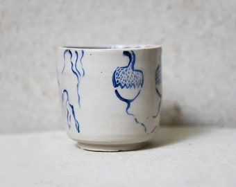 Tasse en céramique blanche et motifs a plan