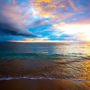 May include: A scenic ocean view at sunset. The sky is filled with vibrant colors, including shades of blue, orange, and yellow. The ocean water is a mix of blue and green, with waves gently rolling onto the sandy shore. The sun is setting on the horizon.