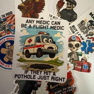 May include: A collection of stickers with medical and paramedic themes. One sticker features an ambulance with the text "Any medic can be a flight medic if they hit a pothole just right." Other stickers show skeleton figures in medical attire.