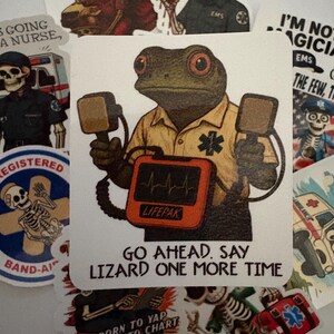 May include: A collection of stickers featuring medical and emergency service themes. One sticker shows a frog paramedic holding a defibrillator with the text "GO AHEAD. SAY LIZARD ONE MORE TIME." Other stickers depict skeletons in EMS uniforms and medical equipment.