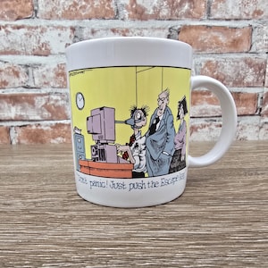 May include: White ceramic mug with a humorous office cartoon. The mug features a yellow background with a cartoon of office workers and the text "Don't panic! Just push the Escape key."