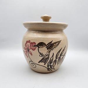 May include: A set of three ceramic mugs with a speckled, matte finish. The mugs are in shades of cream, light gray, and dark gray. Each mug has a simple, minimalist design, perfect for coffee or tea.