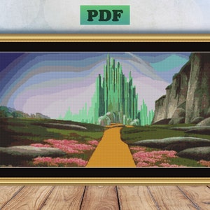 May include: A cross-stitch pattern of the Emerald City from the Wizard of Oz. The city is made of green buildings and is surrounded by a yellow brick road. The city is in the distance, and the foreground shows a field of green grass and pink flowers.