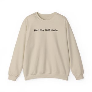 以下が含まれることがあります： ベージュ色のスウェットシャツ。黒字で「Per my last note.」とプリントされています。長袖、クルーネックで、柔らかい素材で作られており、普段使いに最適です。テキストは中央に配置されています。