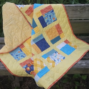 Yellow baby quilt with flowers and birds