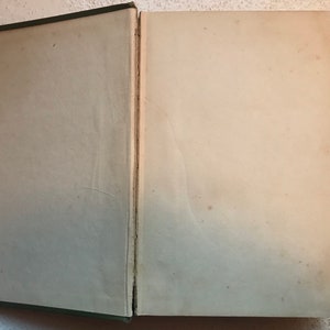 May include: A closed book with a green cover and white pages. The book is open to a blank page.