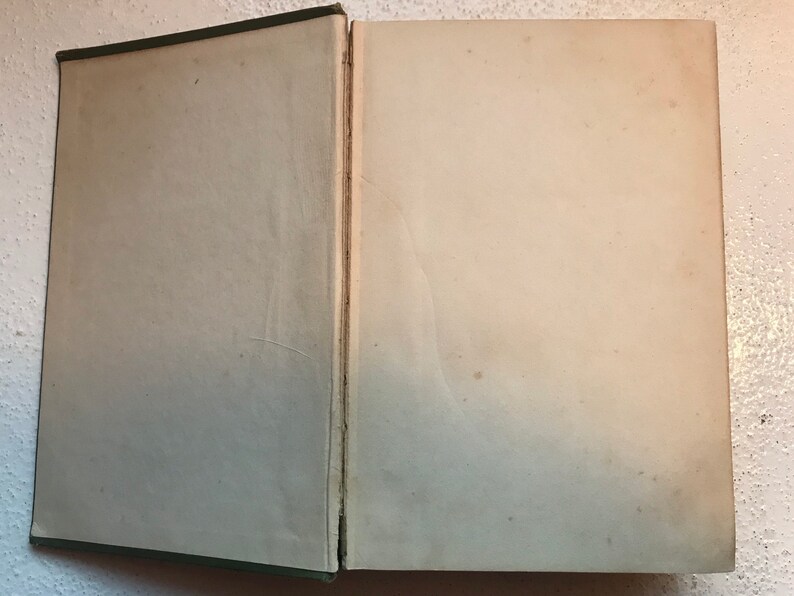 May include: A closed book with a green cover and white pages. The book is open to a blank page.