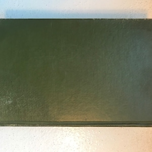 May include: A dark green hardcover book with no visible title or author.