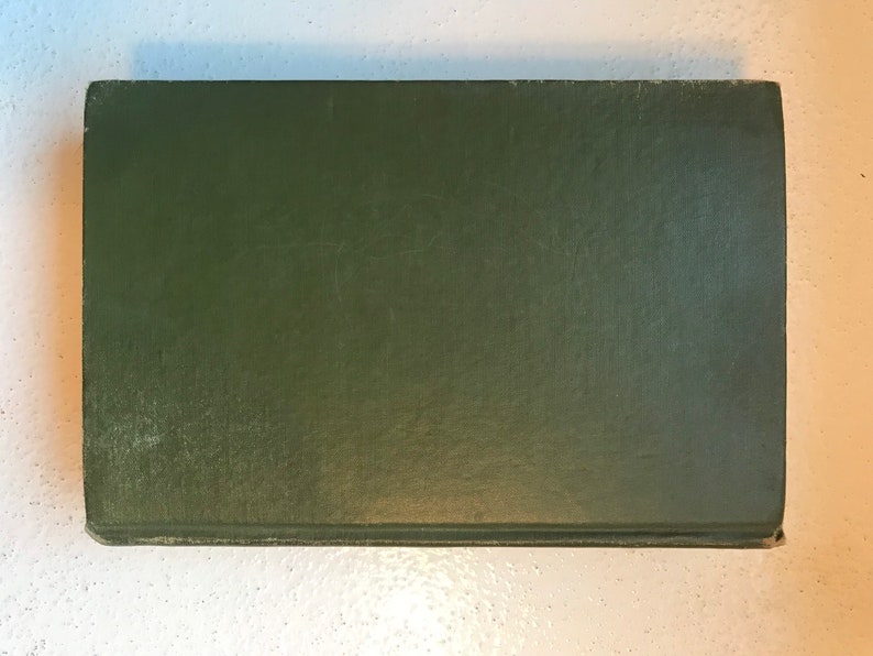 May include: A dark green hardcover book with no visible title or author.