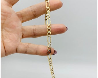 May include: A gold chain bracelet with a figaro link pattern.