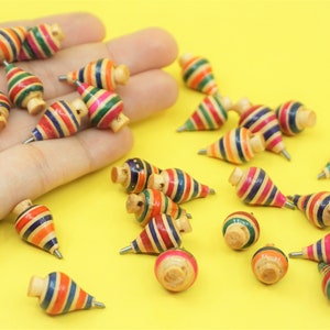 May include: A collection of colourful wooden spinning tops with a pointed tip. The tops are decorated with stripes of red, blue, green, yellow and orange.