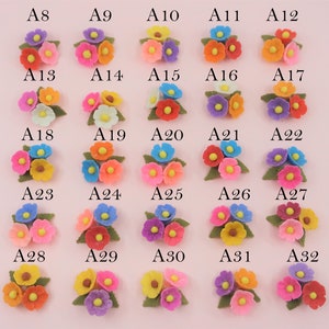 Pode incluir: Uma cole&ccedil;&atilde;o de cachos de flores em miniatura coloridas. Cada cacho apresenta tr&ecirc;s flores em v&aacute;rias cores como rosa, laranja, amarelo e azul, com folhas verdes. A imagem est&aacute; disposta em linhas e colunas, com cada cacho rotulado com uma letra e um n&uacute;mero.