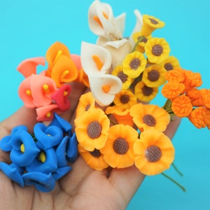 May include: A bouquet of colorful artificial flowers, including blue, orange, white, and yellow flowers. The flowers are made of a soft, pliable material and are perfect for adding a touch of color to any craft project.