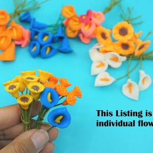 May include: Assortment of artificial flowers in various colors, including blue, orange, yellow, and white. The flowers are arranged in bunches and have a realistic appearance. This listing is for 1 individual flower.