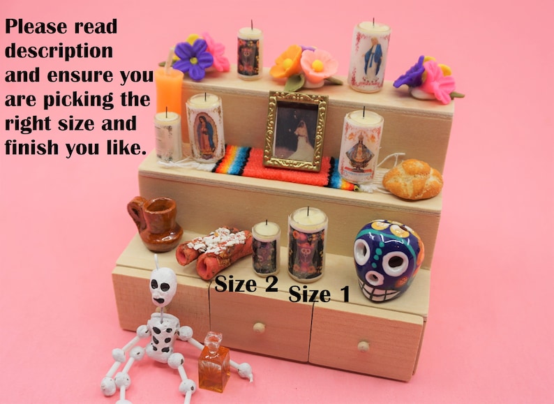 May include: A three-tiered wooden display stand featuring miniature candles with religious imagery, a small framed picture, a colorful woven runner, a bread roll, a brown ceramic mug, a skull figurine, and a white skeleton figure with black spots.