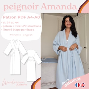 May include: A light blue robe with a white trim and a tie belt. The robe is shown on a model in a bedroom setting. The text "peignoir Amanda" is at the top of the image. The text "Patron PDF A4-A0 du 34 au 44 patron + livret d'instructions illustré étape par étape français - english" is in a pink circle at the top left of the image. The text "niveau débutant" is in a pink circle at the bottom right of the image.