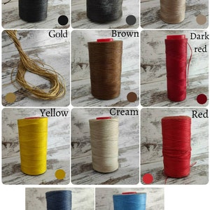 Puede incluir: Una colecci&oacute;n de once carretes de hilo encerado en varios colores, incluyendo negro, marr&oacute;n oscuro, bronceado, oro, marr&oacute;n, rojo oscuro, amarillo, crema, rojo, azul y azul claro. Cada carrete tiene una tapa roja y textura de hilo visible.