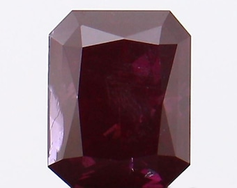 May include: A deep red gemstone with a rectangular emerald cut. The gemstone is faceted and has a high polish.