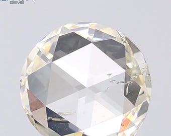 Puede incluir: Un diamante de talla redonda con una superficie compleja y facetada. La gema tiene un tono amarillo pálido y refleja la luz, creando un efecto brillante. El diamante se encuentra sobre un fondo blanco liso, resaltando su claridad y brillo.