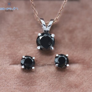 Pu&ograve; includere: Un ciondolo con collana e un set di orecchini abbinati in diamanti neri. Il ciondolo presenta un diamante nero rotondo incastonato in una montatura d'argento. Anche gli orecchini sono diamanti neri rotondi incastonati in argento.