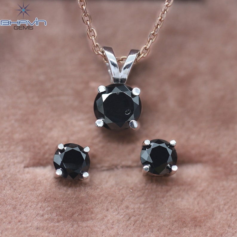 Pu&ograve; includere: Un ciondolo con collana e un set di orecchini abbinati in diamanti neri. Il ciondolo presenta un diamante nero rotondo incastonato in una montatura d'argento. Anche gli orecchini sono diamanti neri rotondi incastonati in argento.