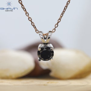 Pu&ograve; includere: Una collana con catena d'argento con un ciondolo di diamante nero.