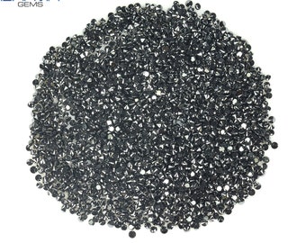 May include: A pile of black diamonds, also known as carbonado diamonds, on a white background.