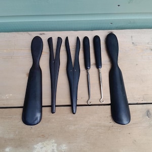 Sammlung von Handschuhspannern, Schuhanziehern und Knopfziehern aus Ebenholz um 1900