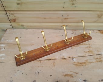 Appendiabiti vintage con quattro ganci in ottone su binario in legno massello.
