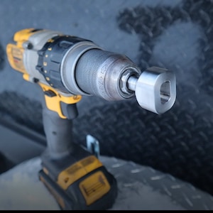 May include: A yellow and black cordless drill with a metal drill bit attachment. The drill has a black and yellow handle and a black trigger.