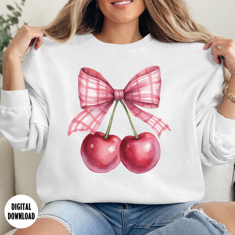 May include: White sweatshirt with a pink and white gingham bow and two red cherries.