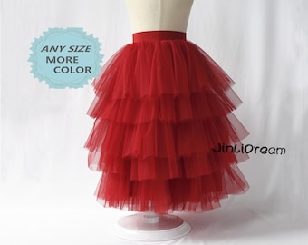 May include: Red tulle skirt with multiple layers, featuring a wide red waistband. The skirt is displayed on a mannequin.