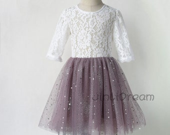 May include: A white lace top with long sleeves and a mauve tulle skirt with silver glitter stars. The skirt is full and flowing.